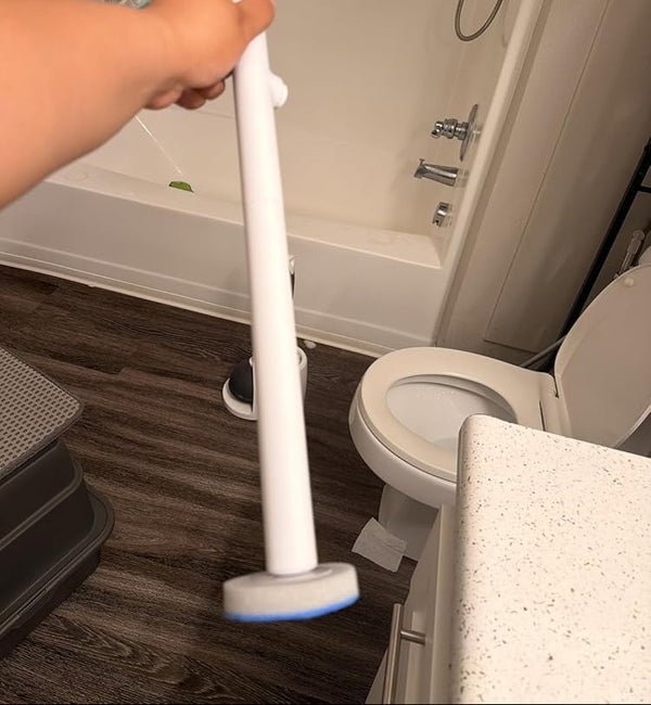 Person using a white cleaning tool in a bathroom setting